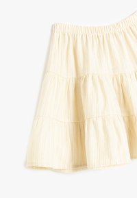 Falda escalonada de color amarillo claro con sutiles rayas verticales y cintura elástica. Presenta una tela suave y texturizada para mayor confort.