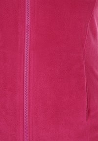 Fleece-vest i klart pink med fuld lynlås, glat tekstur og diskrete sømdetaljer langs syningerne.