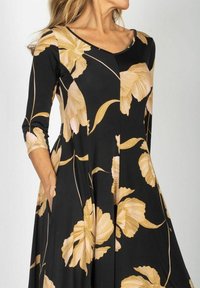Czarna sukienka z rękawami trzyczwartowymi, z dużymi złotymi kwiatowymi nadrukami i rozkloszowanym krojem. Miękka, gładka tkanina z kieszeniami.