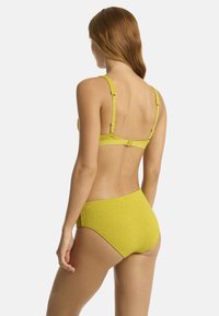 Completo bikini giallo con un design testurizzato, spalline regolabili e chiusura a gancio. La parte superiore presenta un supporto posteriore e un fondo a vita media.