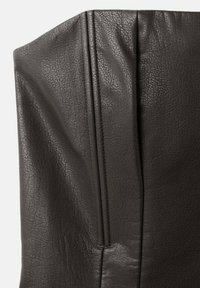 Tmavohnedý kožený materiál s textúrovaným povrchom. Vyznačuje sa výraznými zvislými švami a miernou tuhosťou. Hladký povrch.