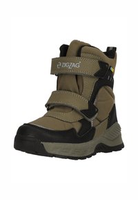Bottines montantes beiges et noires avec des bandes Velcro, tige en synthétique texturé, semelle en caoutchouc, bout renforcé et logo distinctif sur le côté.