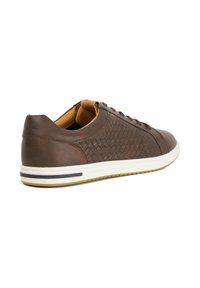 Brown leather sneaker featuring woven texture, round toe, and rubber sole with white and black accents. Laces and cushioned interior.