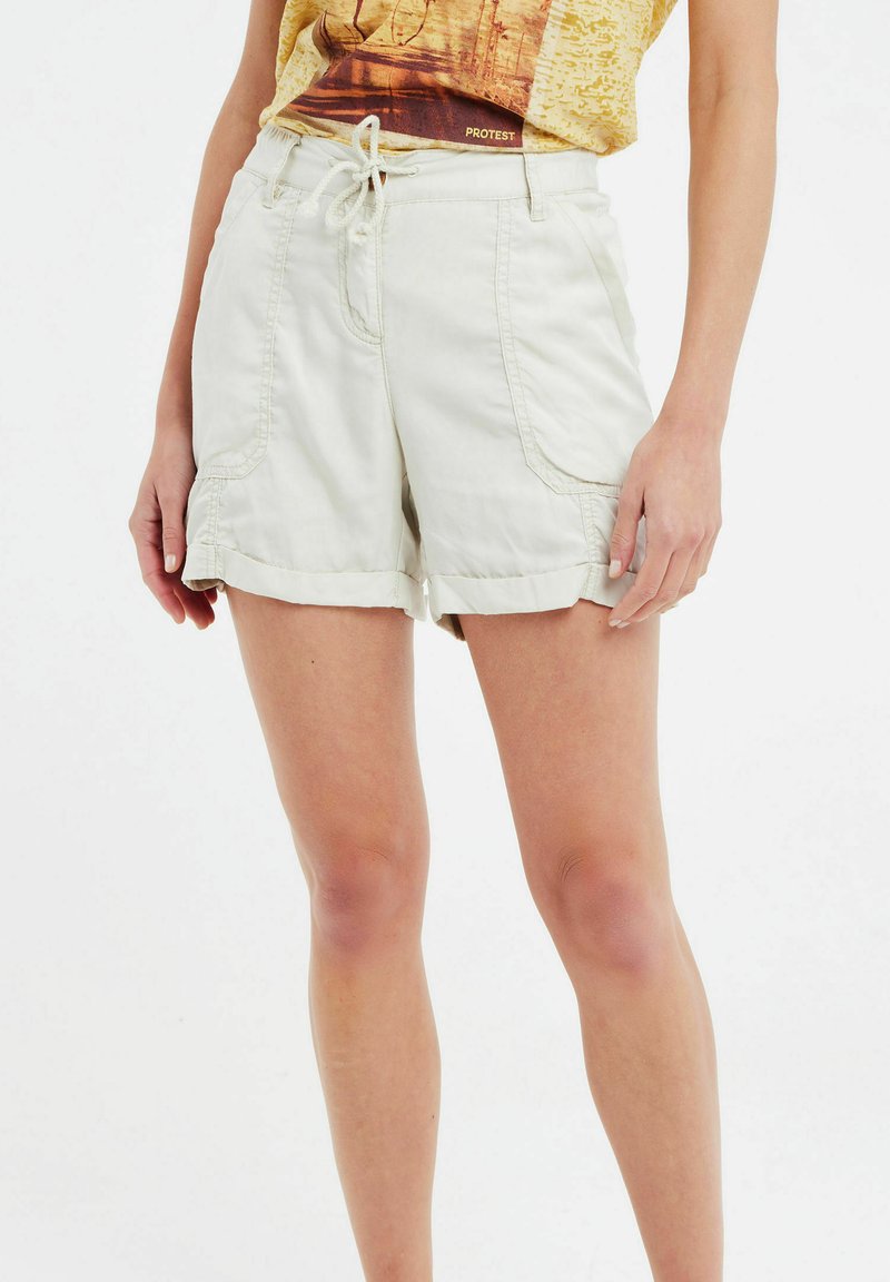 Pantaloni corti beige chiaro con vestibilità rilassata, vita elastica e cordoncino. Presentano tasche laterali e orli ripiegati. Realizzati in tessuto traspirante.