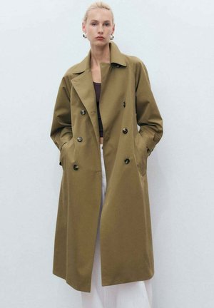 Cappotto trench doppiopetto khaki con colletto, tasche laterali e bottoni neri. Tessuto liscio, vestibilità su misura e maniche lunghe.