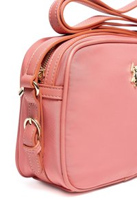 Borsa sintetica rosa con forma rettangolare, dotata di accessori in oro, chiusura con doppia zip e cuciture a vista sulla tracolla.