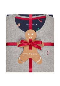 Grijze pyjama-set gestapeld en verpakt met een rode strik. De tag in de vorm van een pepperman heeft tekst, decoratieve details en een zuurstokpatroon op de stof.