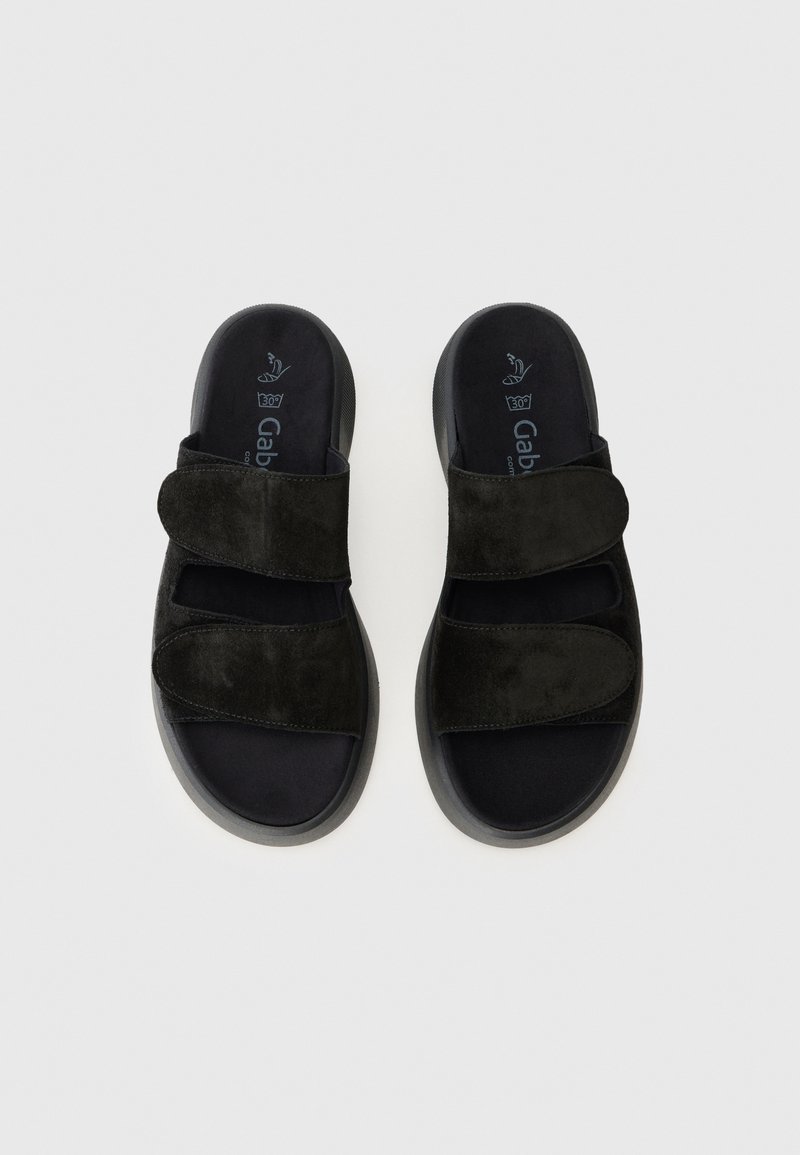 Schwarze Wildledersandalen mit zwei verstellbaren Riemen, einem gepolsterten schwarzen Fußbett und einer strukturierten Gummisohle. Minimalistisches Design mit moderner Form.