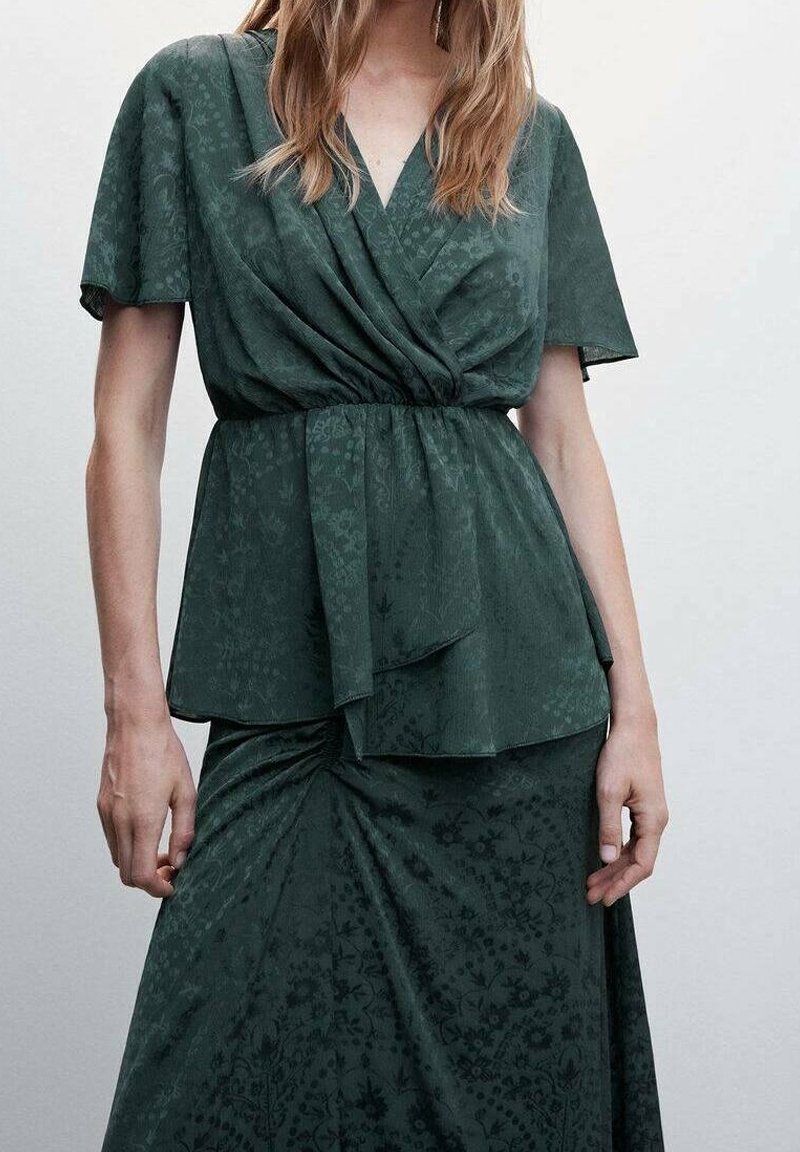 Ciemnozielona, wzorzysta sukienka z dekoltem w serek, krótkimi rękawami i wiązaniem w talii. Miękki materiał z drapowanym przodem i zwiewną spódnicą.
