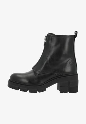Bottine noire en cuir avec semelle crantée épaisse, talon bloc, fermeture éclair latérale et languette à l'arrière.