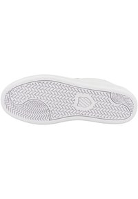 Suola di sneakers bianche con un motivo a zigzag e un accento circolare. Materiale in gomma liscia con un design testurizzato per la presa.