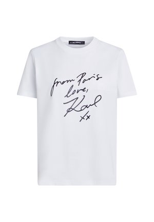 Bela kratka majica s kratkimi rokavi z ročno napisanim črnim besedilom "iz Pariza z ljubeznijo, Karl xx" in okroglim izrezom na vratu.
