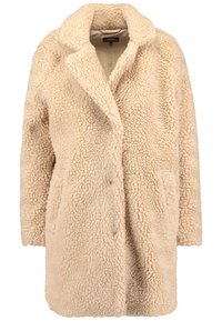 Béžový kabát z faux ovčí vlny s širokým límcem, otevřeným předním dílem a dvěma bočními kapsami. Textura je jemná a sametová, poskytující teplo.