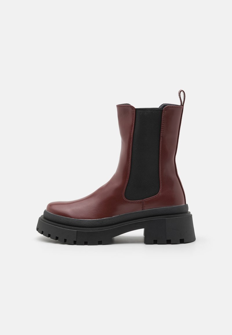 Burgundy ankle boot with a glossy finish, black elastic side panels, thick black sole, and a loop at the back for easy wear.