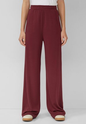 Burgundy wide-leg pants made of a soft fabric, featuring an elastic waistband and pockets, with a smooth texture and relaxed fit.