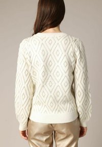 Pull en tricot blanc avec un motif en losanges et des accents dorés, doté de manches bouffantes et d'un ourlet côtelé, vu de dos.
