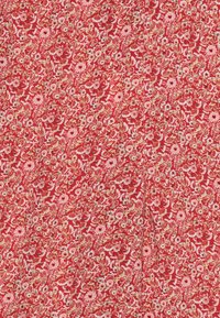 Tessuto rosso con motivi floreali in rosa e crema, con dettagli intricati di foglie e fiori in tutto il tessuto. Texture morbida.