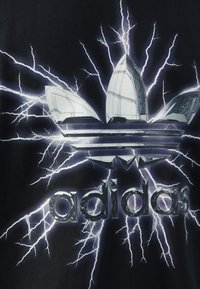Černé tričko s reflexním logem Adidas ve tvaru trojlístku a bleskovými grafikami vyzařujícími od středu.