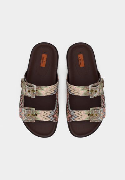 Paire de sandales marron sans lacets avec deux brides à motif zigzag multicolore et boucles, dotées d'une semelle plate et d'une étiquette de marque à l'intérieur.