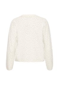 Veste blanche à manches longues avec petits pois noirs, vue de dos, présentant un ourlet droit et un col rond.