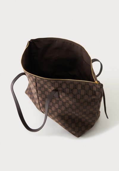 Sac fourre-tout marron avec motif à carreaux noirs, deux poignées foncées, fermeture éclair dorée et intérieur ouvert avec doublure en tissu.