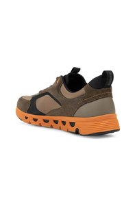 Brown and tan sneaker with a black accent, suede material, and an orange rubber sole featuring grooves and a tab for easy wear.