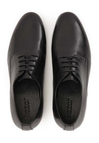 Scarpe eleganti in pelle nera con una texture liscia, design con lacci, punta arrotondata e branding discreto sulla soletta. Suola piatta.