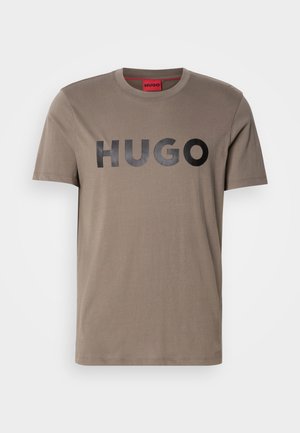 T-shirt caqui feito de algodão, com decote redondo e mangas curtas. Logotipo preto "HUGO" exibido em destaque na parte da frente.