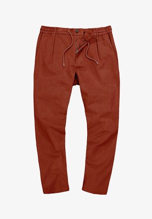 Ruskisan väriset housut, jotka on valmistettu pehmeästä kankaasta. Ne sisältävät joustavyötärön, nyörin, laskoksia ja vetoketjuhalkion.