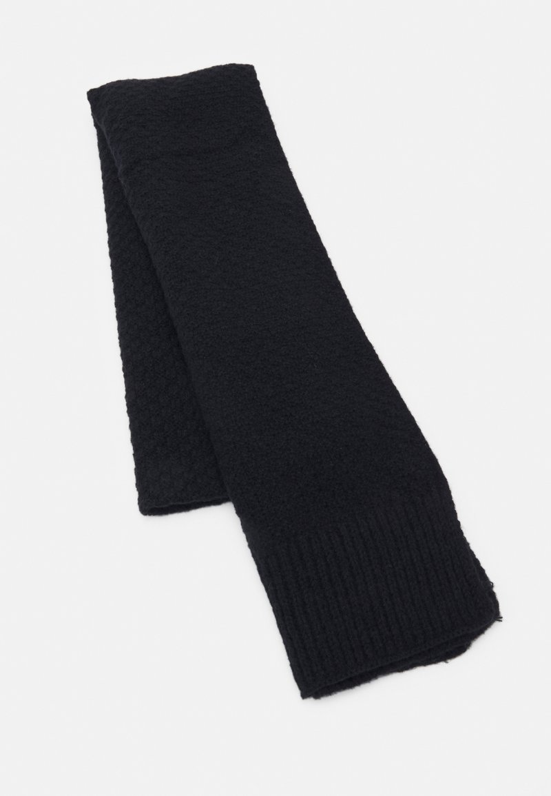Écharpe noire tricotée pliée à plat, présentant des bords côtelés et un motif tricoté texturé sur un côté.
