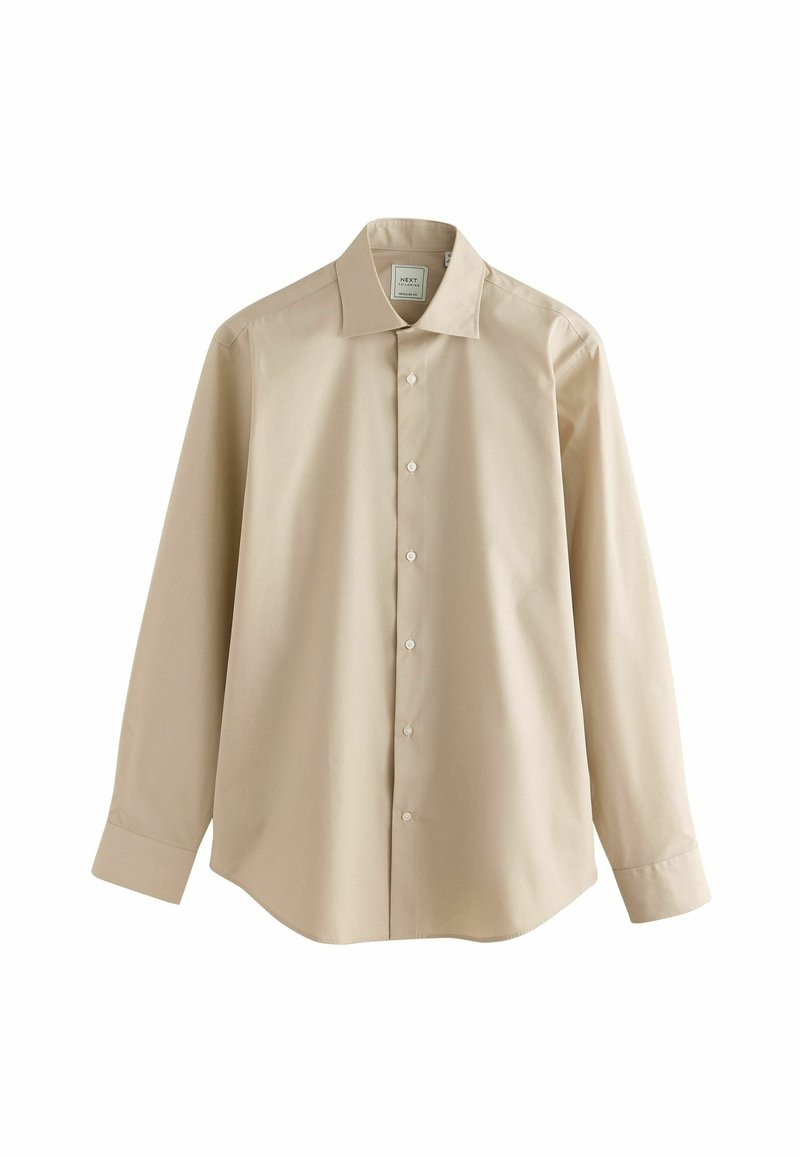 Beige langemouwen overhemd van glad stof, met een puntige kraag en knopen aan de voorkant. Afgeronde zoom en manchetten.