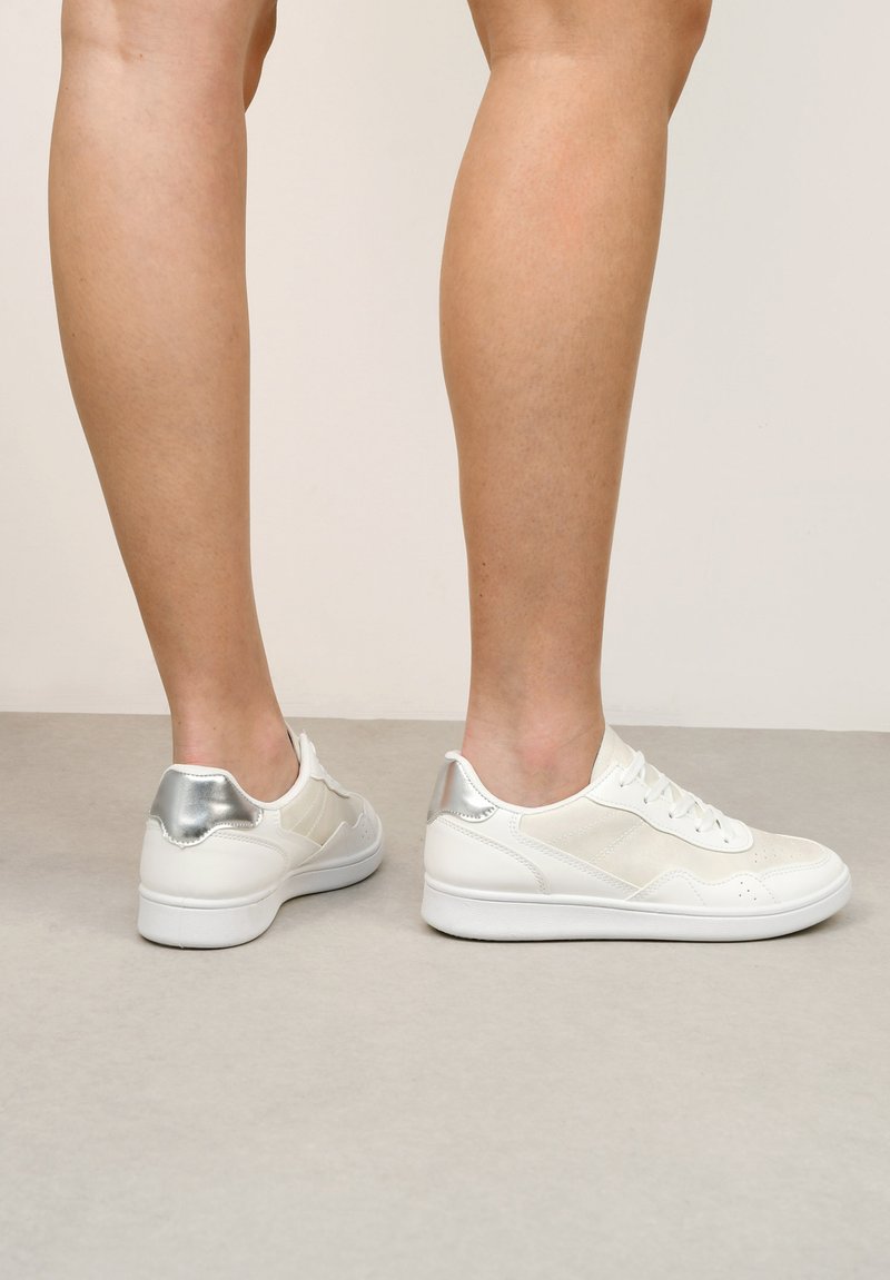 Weiße Sneaker mit silbernen Akzenten, ausgestattet mit einem glatten Lederobermaterial, strukturierten Einsätzen und einer runden Zehenform. Minimalistisches Design mit Schnürsenkeln.