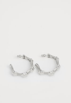 Sølv hoops øreringe med en struktureret, klumpet design. Fremstillet af metal, med en sikker stiftlås og en poleret overflade.