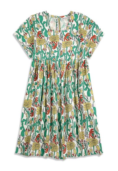 Robe pour enfants à manches courtes avec taille froncée, présentant un motif floral coloré en vert, jaune, rouge et blanc sur un fond clair.