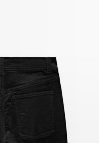Pantaloni in corduroy neri con una superficie testurizzata, dotati di una vita, passanti per la cintura e una tasca posteriore sul lato destro.