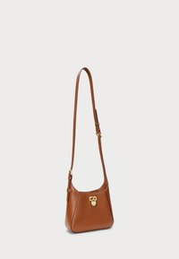 Brown leather shoulder bag with a curved shape, gold hardware, adjustable strap, and a clasp closure at the front. Smooth texture.