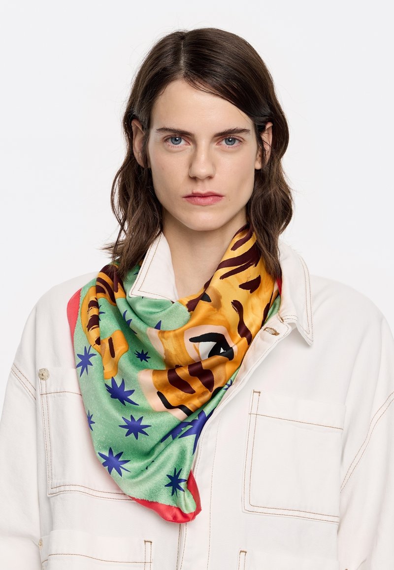 Écharpe en soie avec un motif de tigre multicolore, fond vert avec des rayures orange et marron, accentuée de étoiles bleues.