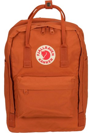 Sac à dos Fjällräven Kånken orange avec une forme rectangulaire, deux poignées sur le dessus, une poche avant et un patch logo circulaire à l'avant.