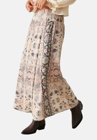 Falda maxi con estampado floral en tejido suave; cuenta con una cintura fruncida, colores pastel con acentos en marrón y una silueta fluida.