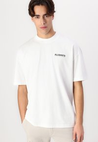 White cotton t-shirt featuring a crew neckline and short sleeves, with a small black "ALLSAINTS" logo on the left chest.