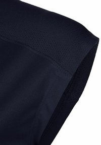 Maglietta sportiva blu navy con spalle, caratterizzata da una texture liscia, pannelli in mesh traspirante e cuciture nette lungo i bordi.