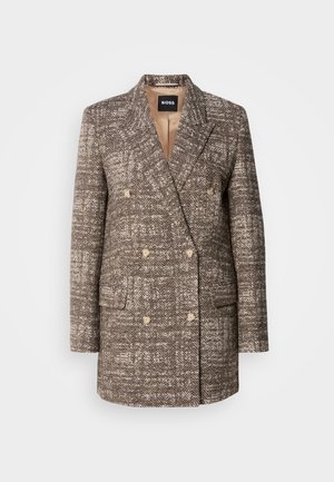 Manteau marron à chevrons double boutonnage avec boutons beiges et revers crantés. Deux poches avant et doublure lisse.