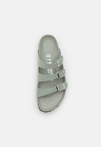 Sandale vert clair à bout ouvert avec trois sangles argentées réglables à boucle et semelle profilée, taille 38 visible à l'intérieur.