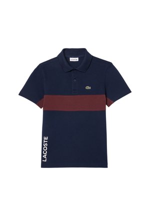 Granatowa koszulka polo z bordową poziomą paską, logo Lacoste na piersi oraz tekst „LACOSTE” pionowo po lewej dolnej stronie.