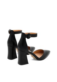 Scarpe nero in pelle con tacco alto, punta affusolata, cinturino alla caviglia e tacco a blocco largo. Texture liscia con foderatura interna color beige.