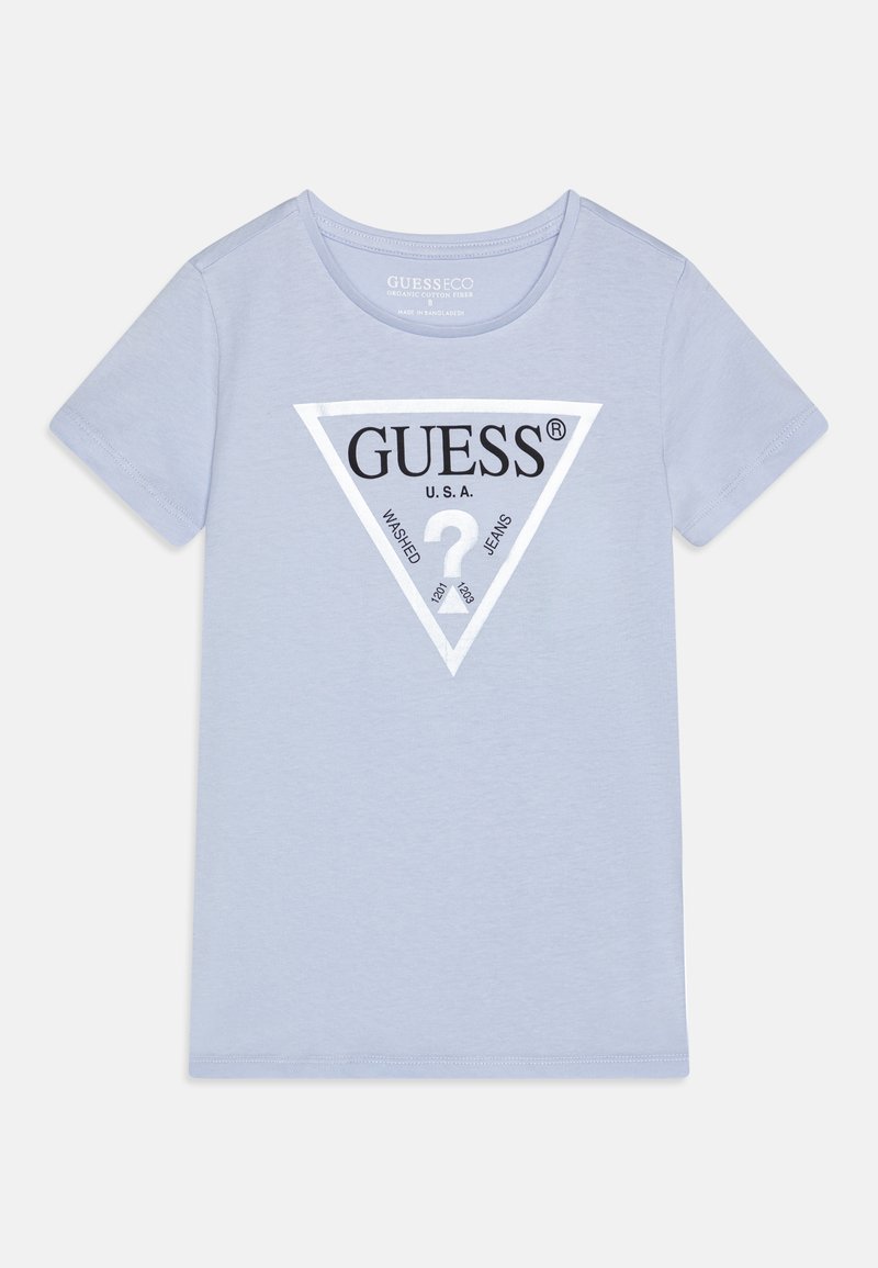 Světle modré bavlněné tričko s trojúhelníkovým černobílým logem a textem "GUESS USA WASHED JEANS" ve středu. Krátké rukávy, kulatý výstřih.