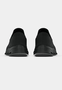 Schwarze Schlupfschuhe mit strukturiertem Obermaterial, flexiblem Schuhsohle mit Aussparungen und einem glatten, minimalistischen Design ohne sichtbare Logos.