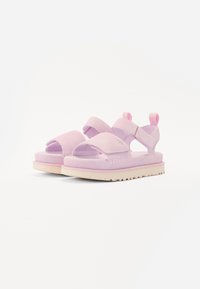 Rosa sandaler med justerbare remmer, mykt semsket materiale, design med åpen tå, og en lys gummisåle med et teksturert mønster.