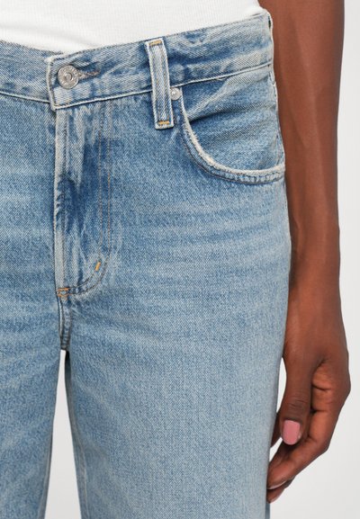 Light blue denim jeans featuring a high waist, classic five-pocket design, and subtle stitching accents. Soft texture and slight distressing.