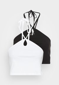 Dois tops cropped, um branco e um preto, com um design de gola halter, fechos com laço e um pequeno recorte em forma de olho na parte da frente.